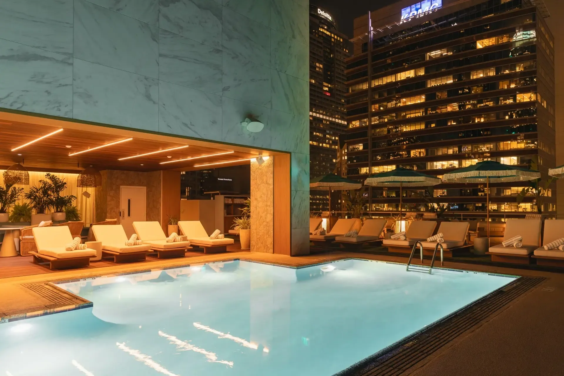 Rooftop pool and chaise lounges at the Delphi Hotel at night